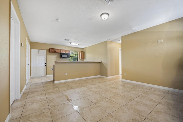 1332 SW G, Belle Glade, FL 33430 - empty room with light tile patterned flooring, a smoke detector, baseboards, and a textured ceiling