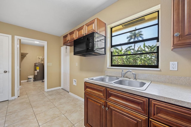 1332 SW G, Belle Glade, FL 33430 - kitchen featuring water heater, black microwave, a sink, and light countertops