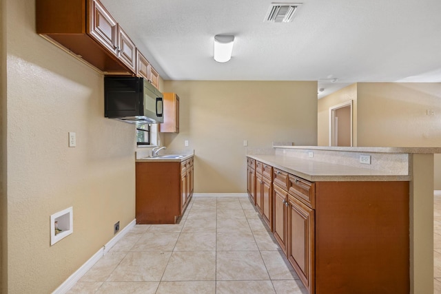 1332 SW G, Belle Glade, FL 33430 - kitchen with brown cabinets, a sink, and light countertops