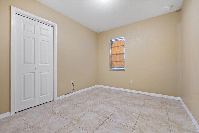 1332 SW G, Belle Glade, FL 33430 - unfurnished bedroom featuring light tile patterned floors, baseboards, and a closet