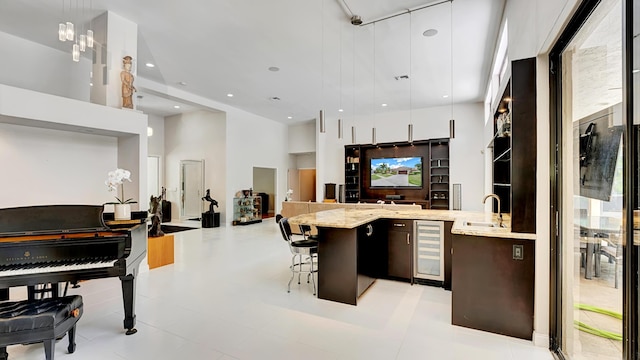 7245 Montrico Dr, Boca Raton, FL 33433 - kitchen with beverage cooler, a sink, modern cabinets, a high ceiling, and a kitchen bar