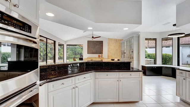 7245 Montrico Dr, Boca Raton, FL 33433 - kitchen with vaulted ceiling, dark stone counters, white cabinets, double oven, and recessed lighting