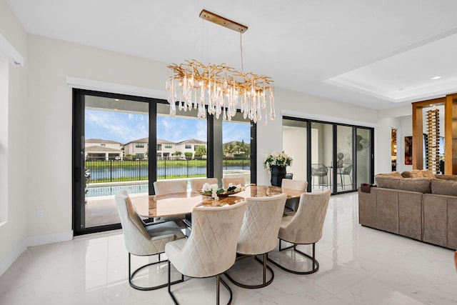 17112 Aquavera Way, Boca Raton, FL 33496 - dining room with a chandelier, light marble finish floors, a water view, and a raised ceiling
