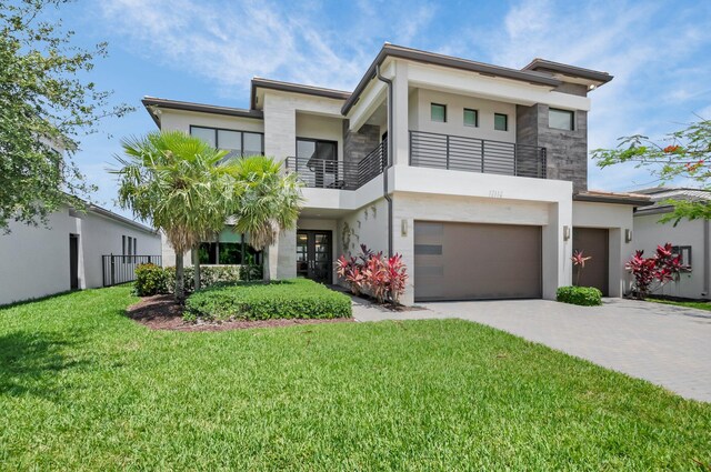 17112 Aquavera Way, Boca Raton, FL 33496 - modern home featuring a balcony, stucco siding, a garage, driveway, and a front yard