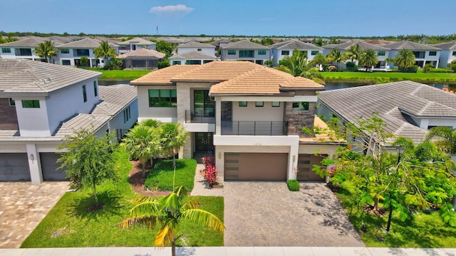 17112 Aquavera Way, Boca Raton, FL 33496 - view of front facade with a balcony, stucco siding, an attached garage, a residential view, and driveway