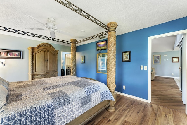 6166 Brandon St, Palm Beach Gardens, FL 33418 - bedroom with a textured ceiling, wood finished floors, ornate columns, a ceiling fan, and baseboards