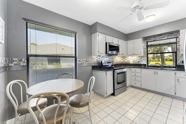 6166 Brandon St, Palm Beach Gardens, FL 33418 - kitchen with stainless steel appliances, dark countertops, and backsplash