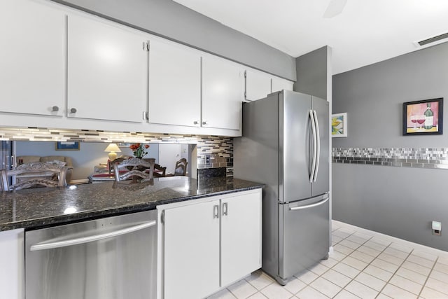 6166 Brandon St, Palm Beach Gardens, FL 33418 - kitchen featuring stainless steel appliances, white cabinetry, decorative backsplash, dark stone countertops, and light tile patterned floors