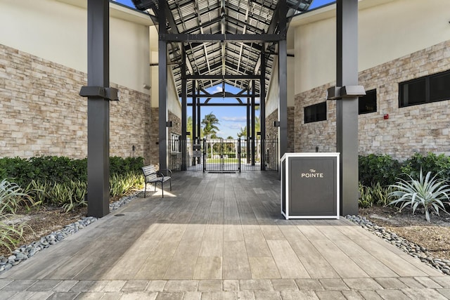 6166 Brandon St, Palm Beach Gardens, FL 33418 - doorway to property featuring stone siding, stucco siding, and a gate