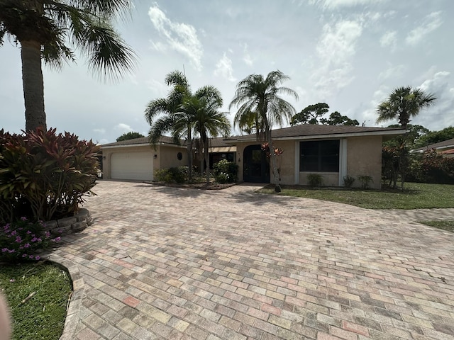 4811 Seagrape Dr, Fort Pierce, FL 34982 - view of front of house with stucco siding, an attached garage, and decorative driveway
