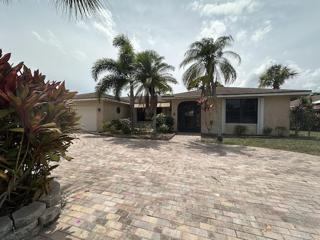 4811 Seagrape Dr, Fort Pierce, FL 34982 - view of front of house with a garage, stucco siding, and decorative driveway