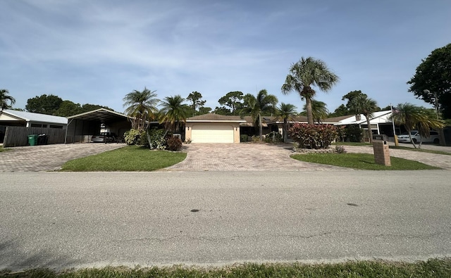 4811 Seagrape Dr, Fort Pierce, FL 34982 - view of front of house featuring decorative driveway, a garage, and a detached carport
