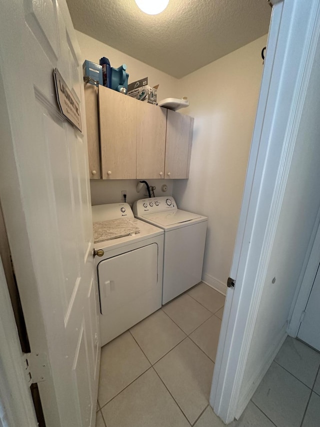 4097 Bluff Harbor Way, Wellington, FL 33449 - washroom with cabinet space, separate washer and dryer, a textured ceiling, light tile patterned flooring, and baseboards
