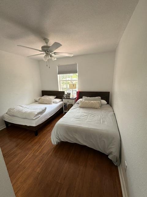 4097 Bluff Harbor Way, Wellington, FL 33449 - bedroom featuring wood finished floors, a ceiling fan, baseboards, and a textured ceiling