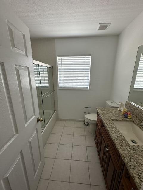 4097 Bluff Harbor Way, Wellington, FL 33449 - full bath featuring vanity, healthy amount of natural light, toilet, tile patterned floors, and a textured ceiling