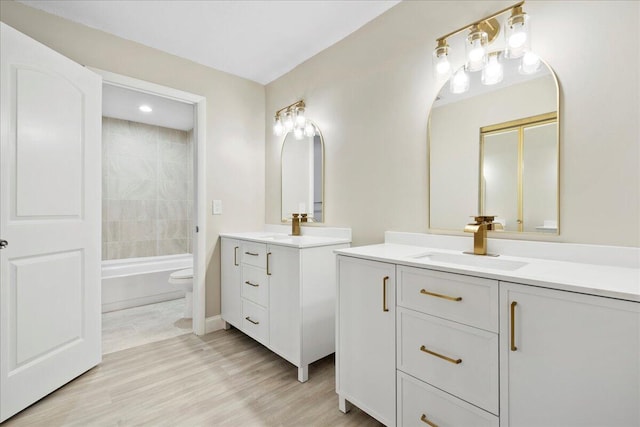 13921 Royal Palm Ct Unit D, Delray Beach, FL 33484 - bathroom featuring two vanities, toilet, wood finished floors, and bathtub / shower combination