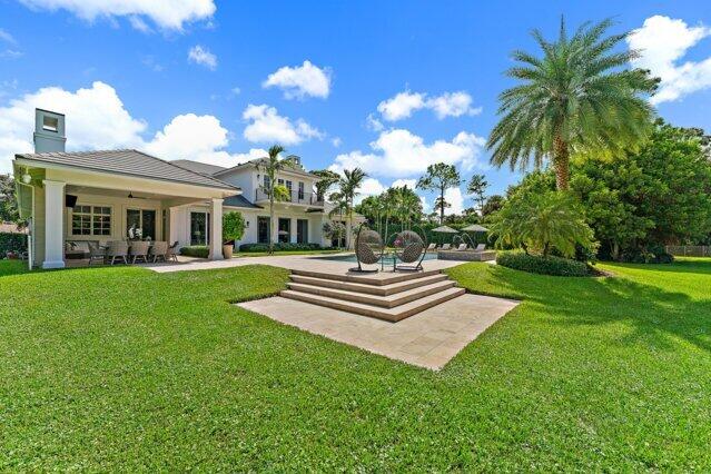 7703 Bold Lad Rd, Palm Beach Gardens, FL 33418 - back of property featuring a yard and a chimney