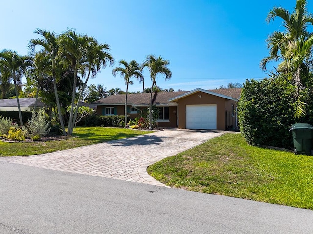 1950 N Conference Dr, Boca Raton, FL 33486 - ranch-style home with decorative driveway, a front yard, a garage, and stucco siding