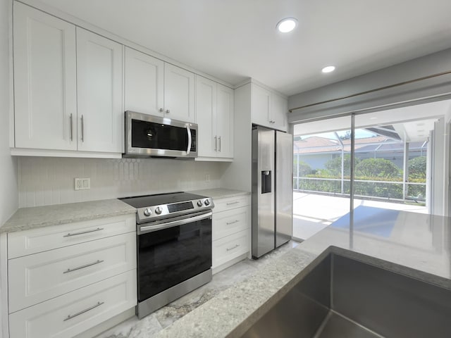 6503 Geminata Oak Ct, Palm Beach Gardens, FL 33410 - kitchen with stainless steel appliances, white cabinets, recessed lighting, and backsplash