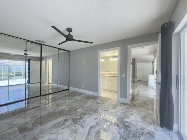 6503 Geminata Oak Ct, Palm Beach Gardens, FL 33410 - unfurnished bedroom with light marble finish floors, access to outside, baseboards, a textured ceiling, and connected bathroom
