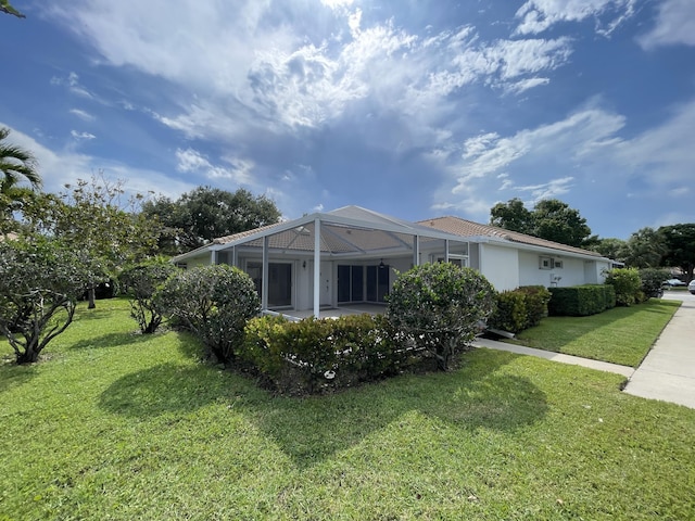 6503 Geminata Oak Ct, Palm Beach Gardens, FL 33410 - view of home's exterior with a lawn, a patio, glass enclosure, and stucco siding