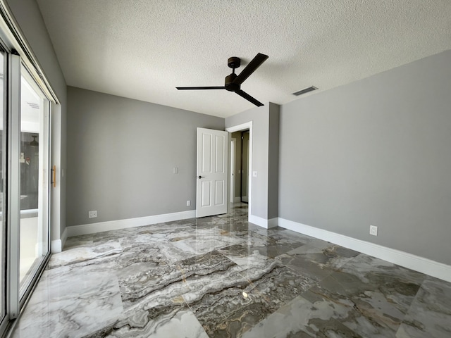 6503 Geminata Oak Ct, Palm Beach Gardens, FL 33410 - unfurnished bedroom featuring marble tiled floors, a textured ceiling, ceiling fan, a closet, and baseboards