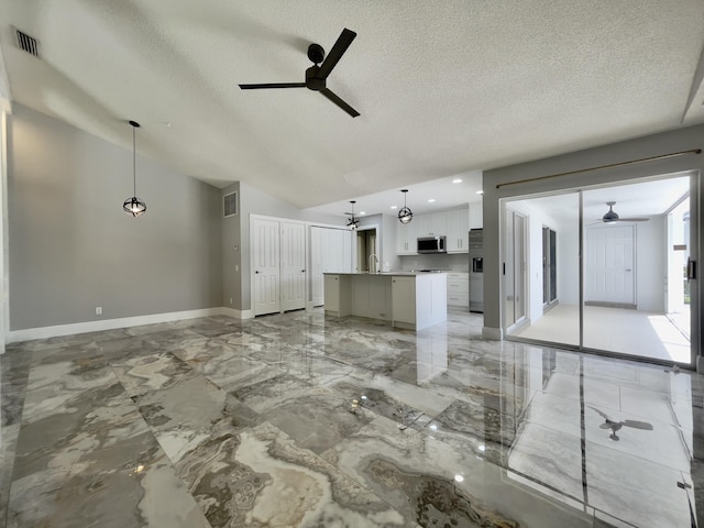6503 Geminata Oak Ct, Palm Beach Gardens, FL 33410 - unfurnished living room featuring a ceiling fan, a textured ceiling, baseboards, vaulted ceiling, and light marble finish floors