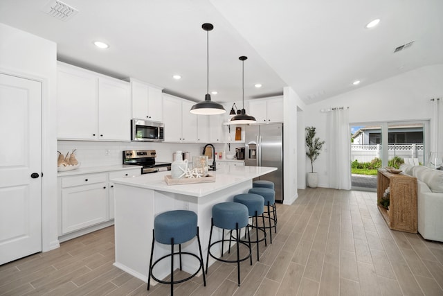 201 Ocarina St SW Unit 78, Palm Bay, FL 32908 - kitchen with stainless steel appliances, light wood-style flooring, a breakfast bar area, tasteful backsplash, and light countertops