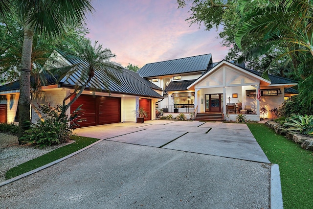 5488 Pennock Point Rd, Jupiter, FL 33458 - view of front of home with covered porch, a standing seam roof, metal roof, and concrete driveway