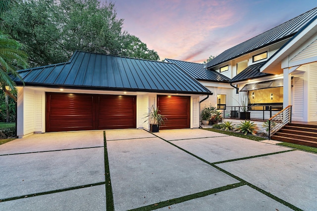 5488 Pennock Point Rd, Jupiter, FL 33458 - view of front of house with a standing seam roof, metal roof, and a garage