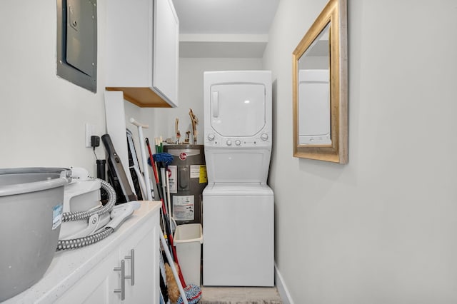 6699 NW 2nd Ave Unit 109, Boca Raton, FL 33487 - laundry area with stacked washer / dryer, electric panel, cabinet space, water heater, and baseboards