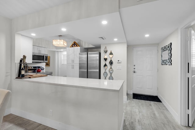 6699 NW 2nd Ave Unit 109, Boca Raton, FL 33487 - kitchen with appliances with stainless steel finishes, a peninsula, light wood finished floors, baseboards, and recessed lighting