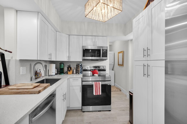 6699 NW 2nd Ave Unit 109, Boca Raton, FL 33487 - kitchen featuring appliances with stainless steel finishes, a sink, light countertops, white cabinets, and light wood finished floors