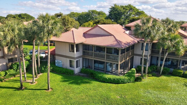 19411 Sabal Lake Dr Unit 5018, Boca Raton, FL 33434 - back of house featuring a tiled roof, a lawn, and a sunroom