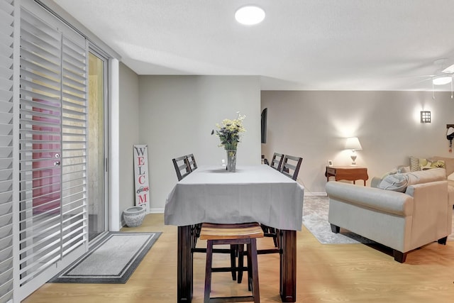 700 Scotia Dr Unit 202, Hypoluxo, FL 33462 - dining area featuring light wood-style floors, a ceiling fan, baseboards, and a textured ceiling