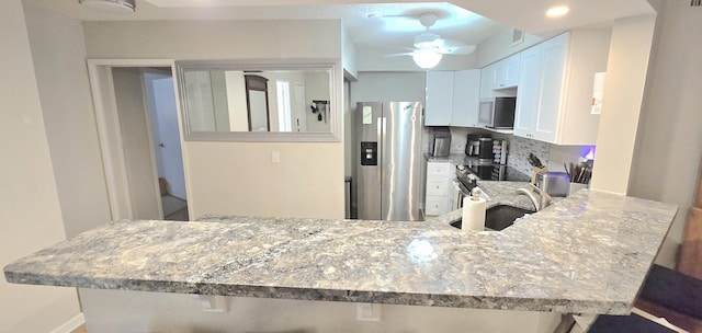 700 Scotia Dr Unit 202, Hypoluxo, FL 33462 - kitchen with appliances with stainless steel finishes, a peninsula, light stone countertops, and ceiling fan