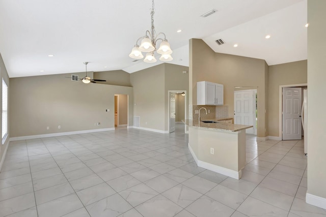 1897 SW Lofgren Ave, Port Saint Lucie, FL 34953 - kitchen featuring a sink, high vaulted ceiling, a chandelier, white cabinetry, and light stone countertops