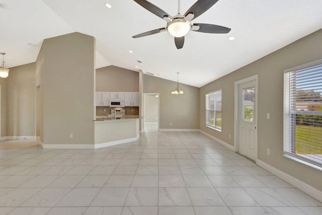 1897 SW Lofgren Ave, Port Saint Lucie, FL 34953 - unfurnished living room featuring lofted ceiling, a ceiling fan, a chandelier, light marble finish floors, and recessed lighting