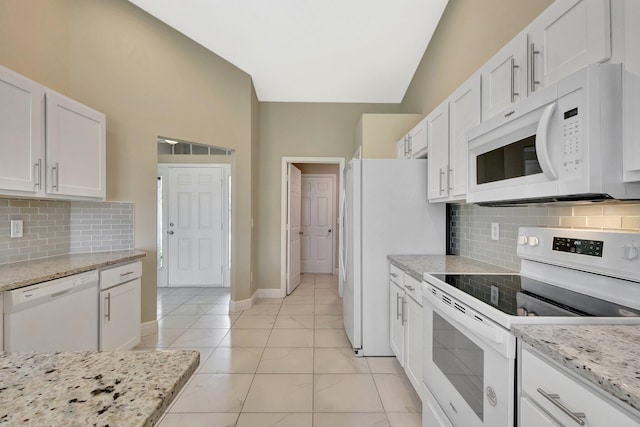 1897 SW Lofgren Ave, Port Saint Lucie, FL 34953 - kitchen featuring white appliances, white cabinets, decorative backsplash, light stone counters, and baseboards
