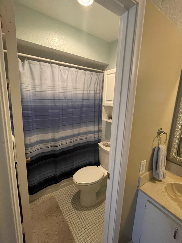 829 Camino Rd Unit 206-C, Delray Beach, FL 33445 - bathroom with toilet, vanity, tile patterned flooring, a textured wall, and curtained shower
