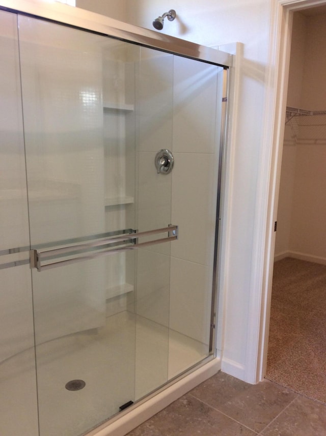 10552 SW Toren Way, Port Saint Lucie, FL 34987 - full bathroom with a shower stall, a walk in closet, and baseboards