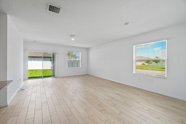 5174 Armina Pl, Fort Pierce, FL 34951 - unfurnished room with light wood-style floors, a textured ceiling, and baseboards