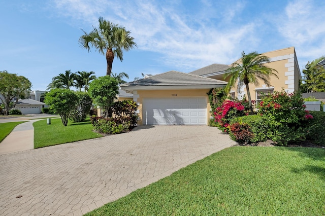 7729 Travlers Tree Dr, Boca Raton, FL 33433 - view of front of home with stucco siding, decorative driveway, a front lawn, and an attached garage