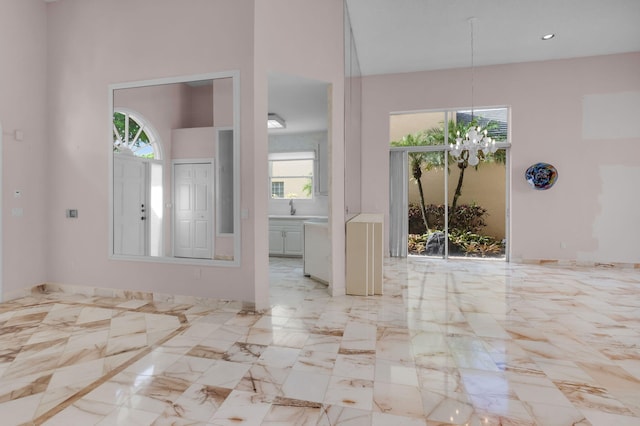 7729 Travlers Tree Dr, Boca Raton, FL 33433 - spare room with a chandelier, a sink, light marble finish floors, and a towering ceiling