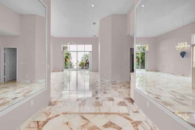 7729 Travlers Tree Dr, Boca Raton, FL 33433 - corridor with a towering ceiling, recessed lighting, light marble finish flooring, a chandelier, and baseboards