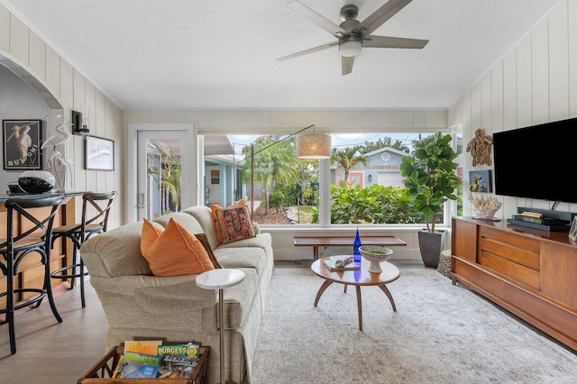 164 Bryn Mawr Dr, Lake Worth Beach, FL 33460 - living room with a ceiling fan, wood finished floors, a textured ceiling, wood walls, and arched walkways