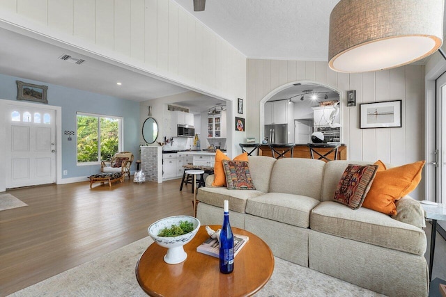 164 Bryn Mawr Dr, Lake Worth Beach, FL 33460 - living room with wood finished floors, arched walkways, and wooden walls
