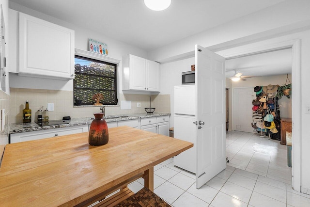 164 Bryn Mawr Dr, Lake Worth Beach, FL 33460 - kitchen with white cabinetry, backsplash, and freestanding refrigerator