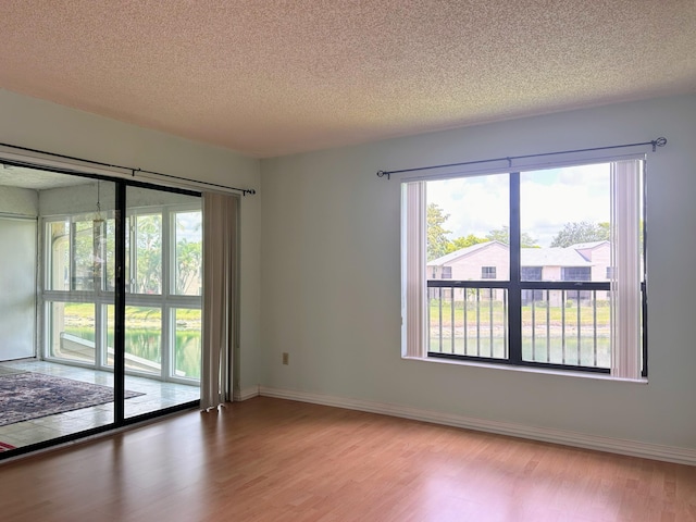 3400 NW 47th Ave Unit 3161, Coconut Creek, FL 33063 - spare room featuring wood finished floors, a textured ceiling, healthy amount of natural light, and baseboards