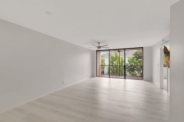 4345 Trevi Ct Unit 203, Lake Worth, FL 33467 - empty room with expansive windows, light wood finished floors, ceiling fan, and baseboards